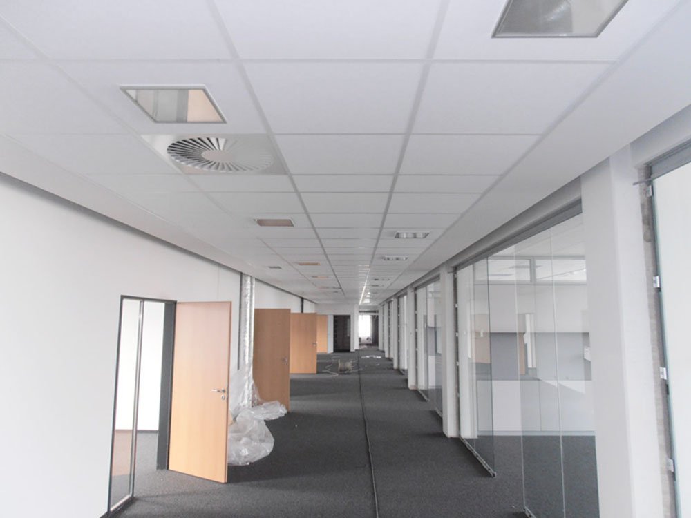 Trockenbauarbeiten im modernen Büro- und Gewerbeausbau Büroflur mit Trockenbauwänden, Deckensystemen und Glasabtrennungen während der Ausbauphase